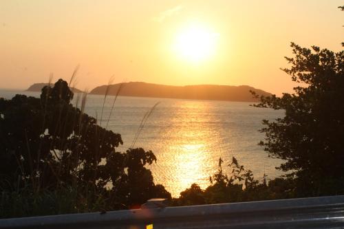 a sunset over a body of water with the sun setting at Cham Island Smiles Homestay in Tân Hiệp