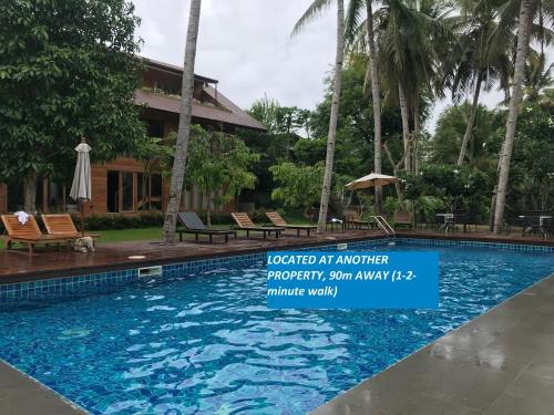 a swimming pool in front of a resort at Riverhouse Hotel (The Teak House) in Mae Sariang