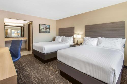 a hotel room with two beds and a desk at Days Inn Merced / Yosemite Area in Merced