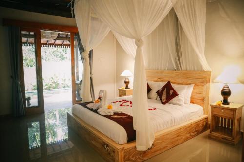 een slaapkamer met een hemelbed bij Private Villa with nature atmosphere by Pondok Dino in Ubud