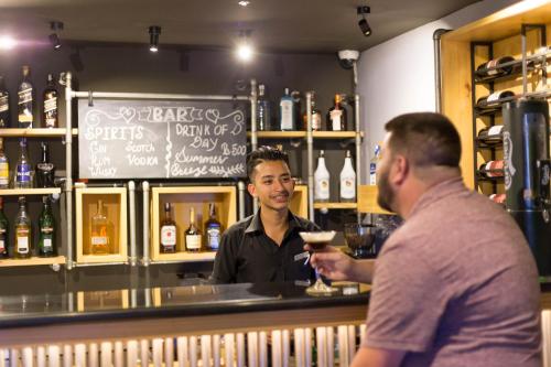 a man standing at a bar holding a glass of wine at Traditional Comfort Boutique Hotel in Kathmandu