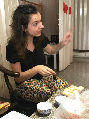 a woman sitting at a table with a piece of cake at 集集藝術家背包客之家Jiji Art Backpackers Hostel in Jiji