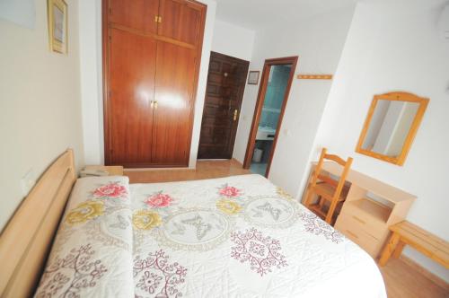 a bedroom with a bed with a white bedspread at Hotel Goya in Almuñécar