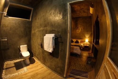 ein Bad mit WC und ein Bett in einem Zimmer in der Unterkunft KATON HILLS in Nusa Penida