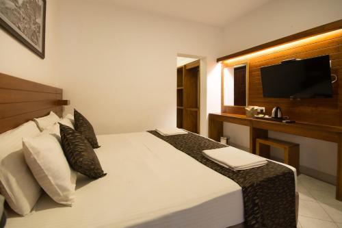 a hotel room with a bed with a flat screen tv at Kandyan View Holiday Bungalow free pickup from kandy in Kandy