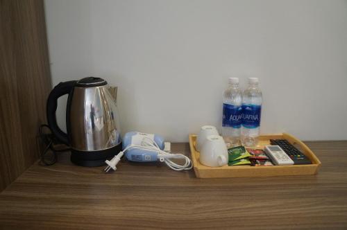 a tray with a coffee maker and water bottles on a table at New Sky Airport Hotel in Noi Bai