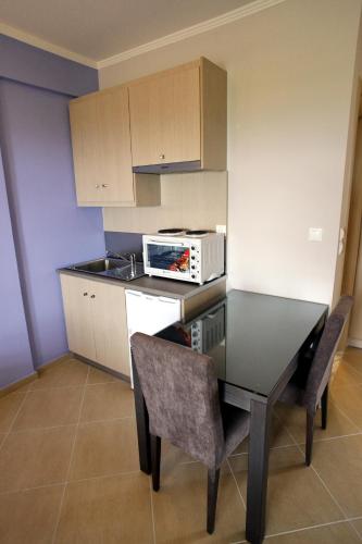 a kitchen with a table with chairs and a microwave at Cavos Fokidos in Chiliadou