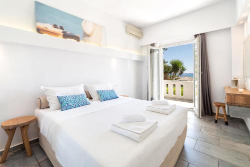 a bedroom with a large bed with a view of the ocean at Golden Beach Hotel in Chrissi Akti