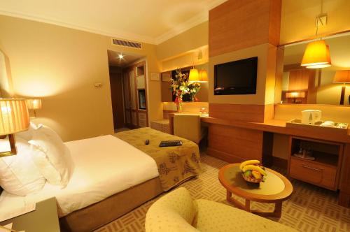 a hotel room with a bed and a television at Tugcan Hotel in Gaziantep