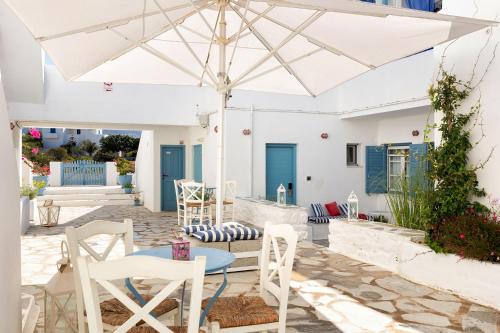 a patio with a table and chairs and an umbrella at Fivos Apartments in Aliki