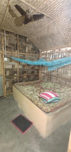a bed in a wooden room with a mattressitures at Elephant and Four wise men resort in Neil Island