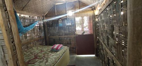 um quarto com uma rede de descanso num quarto com paredes de madeira em Elephant and Four wise men resort em Neil Island