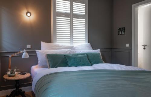 a bedroom with a blue and white bed with a window at Konrads Limburg - Hotel & Gästehaus in Limburg an der Lahn