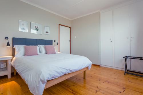 a bedroom with a large bed with a blue headboard at Oceanfront bungalow 3 br/2 ba, Wifi Fireplace: Guppy Huys in De Kelders