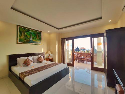 una camera con un grande letto e un balcone di Kubu Taman Home Stay ad Ubud