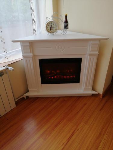 a white fireplace with a clock on top of it at Casa Ovi și Simo in Haţeg
