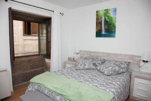 Schlafzimmer mit einem Bett und einem Fenster in der Unterkunft Piso das Costureiras in Pontevedra