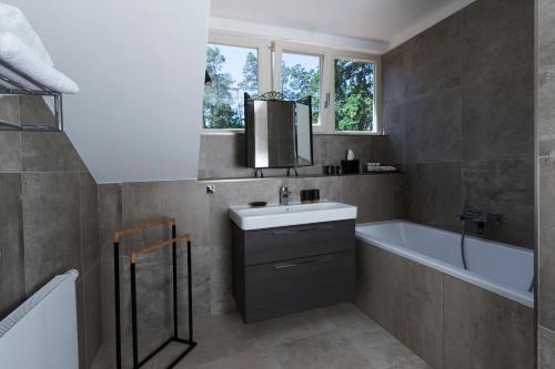 a bathroom with a sink and a bath tub and a bath tub at Areal Botanika in Unhošť