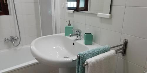 a white bathroom with a sink and a bath tub at A&G Apartments in Zanica
