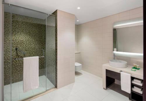 a bathroom with a shower and a sink and a toilet at Hyatt Place Dubai Jumeirah Residences in Dubai