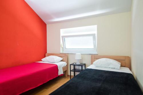 Duas camas num quarto com paredes vermelhas e brancas em Kuća za odmor Nature em Cerje