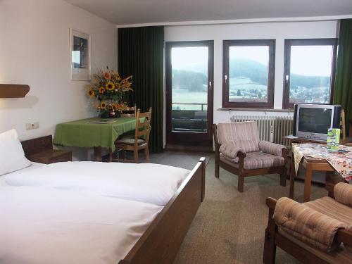 una camera d'albergo con letto, tavolo e TV di hotel rappen a Baiersbronn