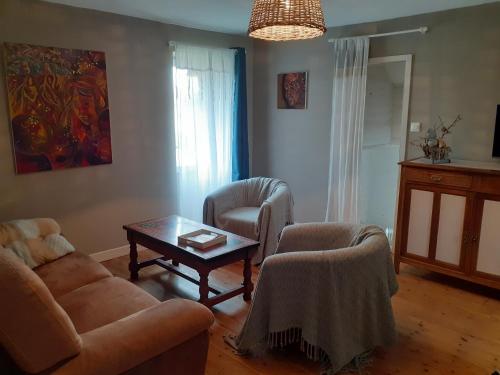 a living room with a couch and chairs and a table at Gîte de Gravelle in Chavin