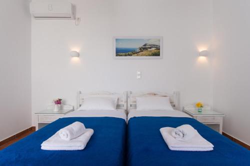 a bedroom with two beds with towels on them at Aegeo Hotel in Chora Folegandros