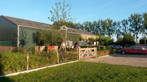 a house with a fence in front of a yard at Boerderij Hazenveld in Kockengen