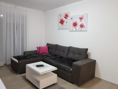 a living room with a brown couch and a table at Apartment GEA 18 in Novi Sad