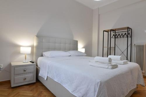 una camera da letto con un letto bianco e asciugamani di A&F Leisure and Business,Kolonaki Apartment ad Atene