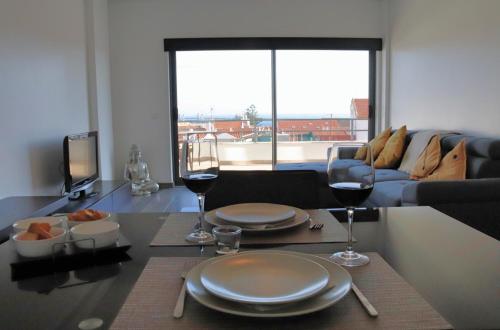 a living room with a table with two glasses of wine at Castle in Blue Apartments-Sea View in Sines