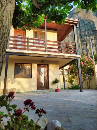 a house with a balcony on top of it at Guesthouse Kastelia in Kalabaka