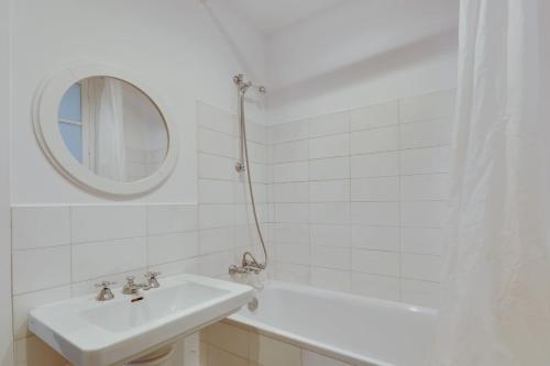 une salle de bain blanche avec un lavabo et un miroir dans l'établissement Unit 009 - Saint Germain des Près (Cherche Midi), à Paris