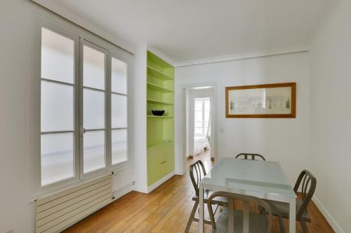 une salle à manger avec des murs blancs et des touches de vert dans l'établissement Unit 009 - Saint Germain des Près (Cherche Midi), à Paris