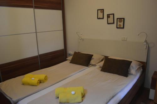 um quarto com 2 camas com toalhas amarelas em APARTMENT TERRA, Koper center em Koper
