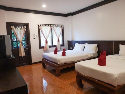 two beds in a room with two red candles on them at Lanta Sea House in Ko Lanta