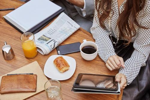 a woman sitting at a table with a plate of food at Hyatt Place Dubai Jumeirah in Dubai