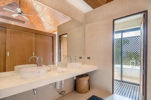 a bathroom with two sinks and a large mirror at 5 Bedroom Sea View Villa Bubbles SDV376 By Samui Dream Villas in Mae Nam