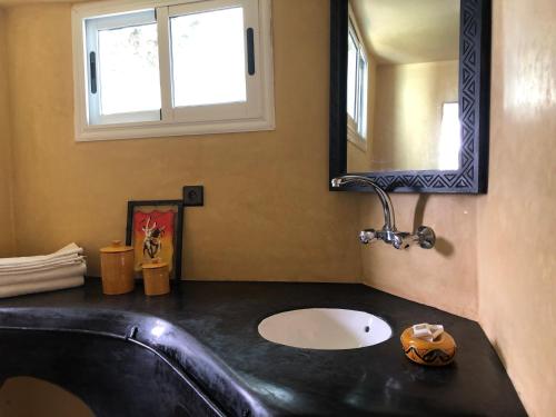 a bathroom with a black sink and a mirror at Villa Jardin De l'Ocean in Aourir