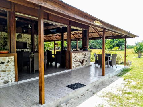 Ecoresort Sumba Dream في Rindi: جناح خشبي مع طاولة وكراسي