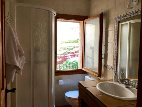 baño con lavabo y aseo y ventana en El Hayuco de Montejo, en Montejo de la Sierra