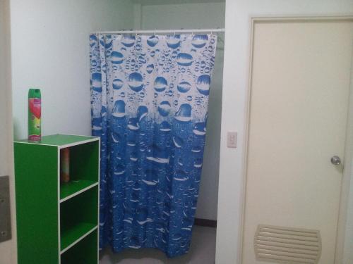 Zimmer mit einem blauen Duschvorhang und einer Tür in der Unterkunft Bungalow 36 m2 sur terrain 400m2 avec Piscine privée a 12km de BAN DUNG in Ban Dung