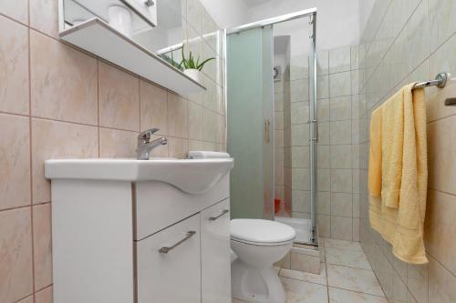 a white bathroom with a sink and a toilet at Dado A6 Apartments in Igrane