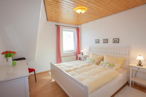 a bedroom with a white bed and a window at Haus Fünfschläfer in Dreschvitz