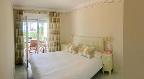 ミハス・コスタにあるMI CAPRICHO, Beachfront, Grownfloor, Private Garden & Terraceのベッドルーム(白いベッド1台、バルコニー付)