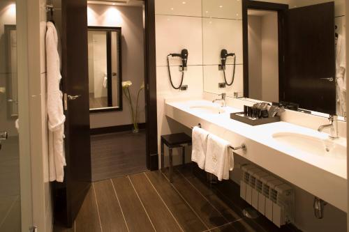 a bathroom with two sinks and a large mirror at Hotel Boutique Gareus in Valladolid