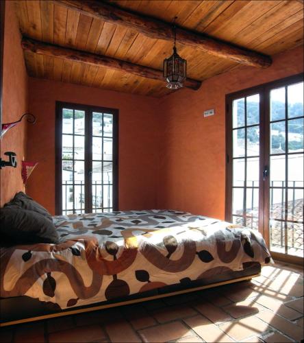 a bedroom with a bed in a room with windows at jade in Ubrique