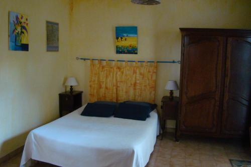 a bedroom with a white bed with blue pillows at l'Orée du Bois in Saint-Maximin-la-Sainte-Baume