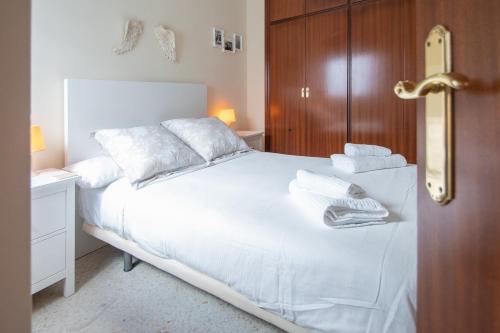 - une chambre avec un lit blanc et une armoire en bois dans l'établissement Apartment Cadiz´s Angel, à Cadix